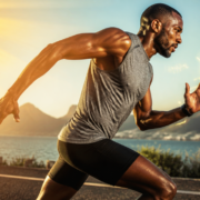High-quality, dynamic image of an athlete (e.g., runner, weightlifter) in action, with subtle, abstract representations of vitamin D (like sun rays or a molecular structure) integrated into the background or around the athlete, symbolizing energy and performance. Focus on health, strength, and vitality. Realistic, vibrant colors, athletic build, determined expression. Avoid overly scientific or clinical looks. Emphasize peak performance and well-being.